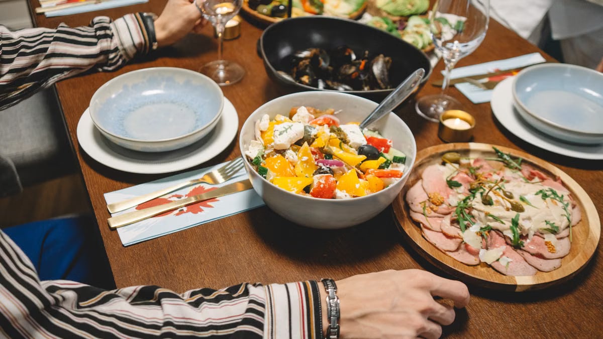 A vibrant dining table setting featuring a colorful salad, seafood, and more.